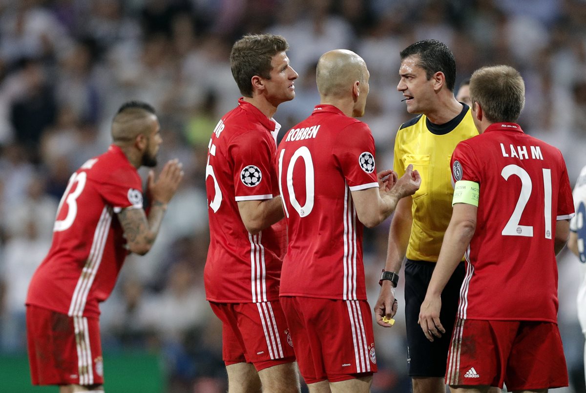 El árbitro Viktor Kassai recibe reclamos de los jugadores del Bayern Múnich ante la expulsión de Arturo Vidal. (Foto Prensa Libre: AFP)