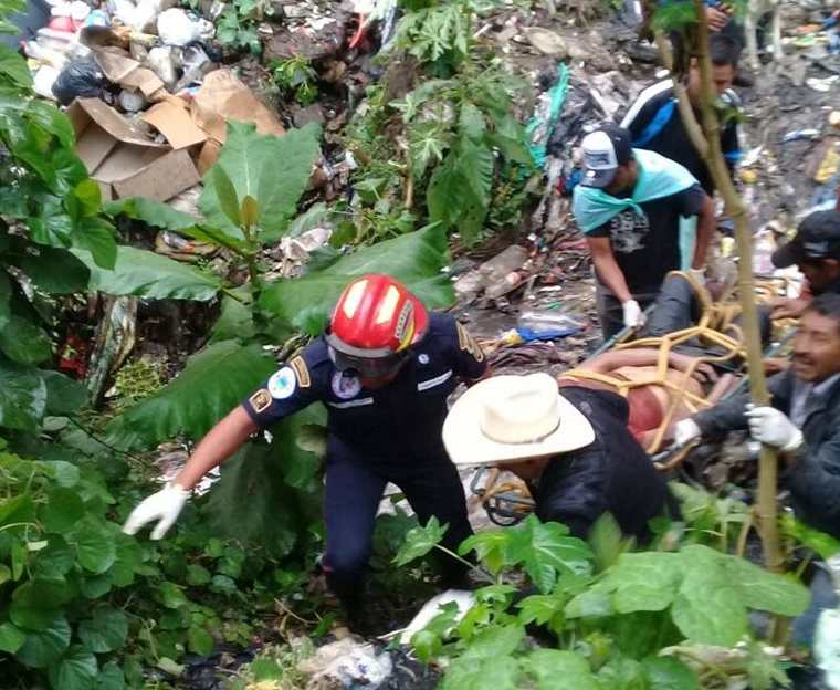 Recolectores ayudan a los socorristas a rescatar el el cadáver. (Foto Prensa Libre: Víctor Chamalé)
