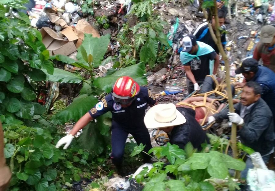 Recolectores ayudan a los socorristas a rescatar el el cadáver. (Foto Prensa Libre: Víctor Chamalé)