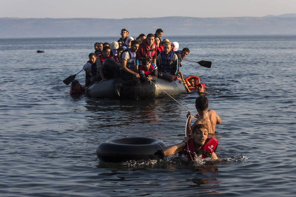 Una embarcación frágil, cargada de migrantes de Oriente Medio, llega a las costas de Grecia. (AP)