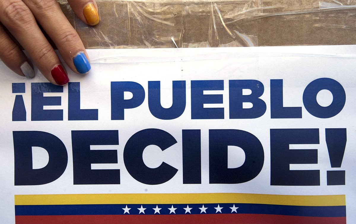 Más de 14 mil mesas están habilitadas para la consulta popular en Venezuela. Venezolanos en el extranjero votaron el sábado último. (Foto Prensa Libre: EFE)