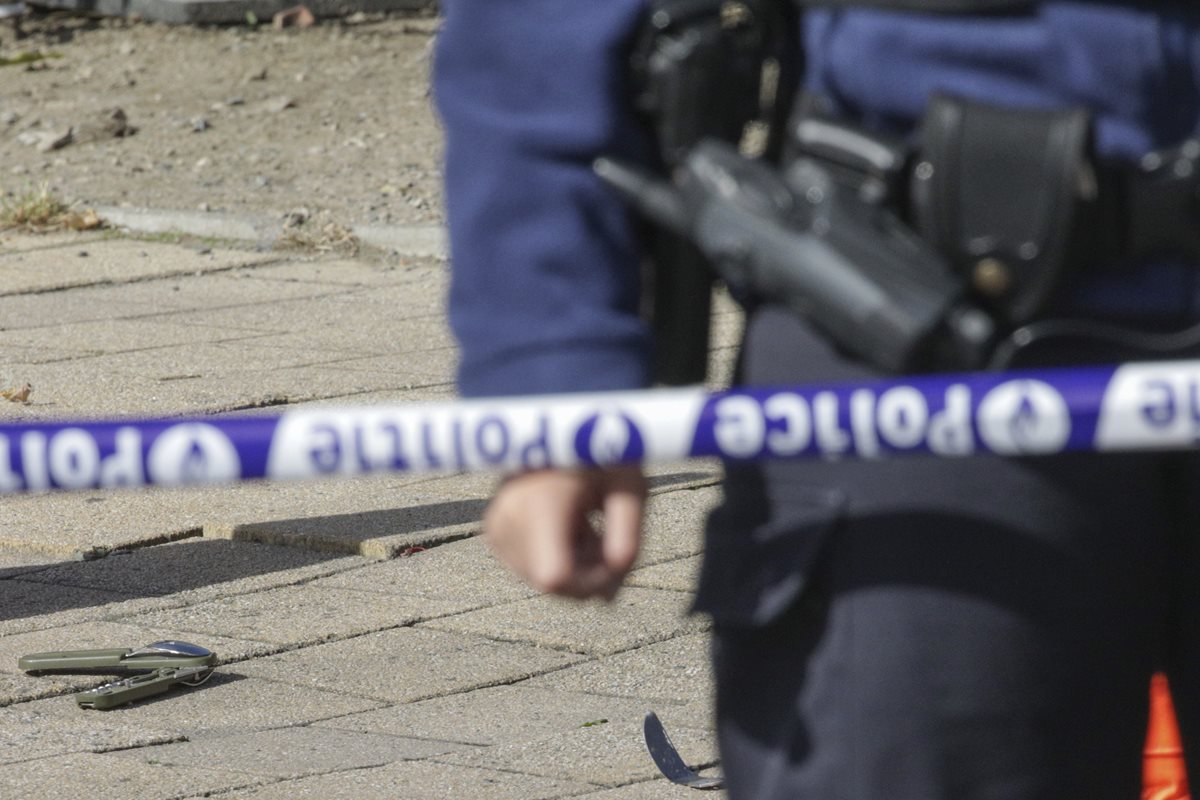 Un policía resguarda la escena del ataque a dos de sus colegas en Bruselas. Abajo se observa el cuchillo usado por el atacante. (Foto Prensa Libre: AP).
