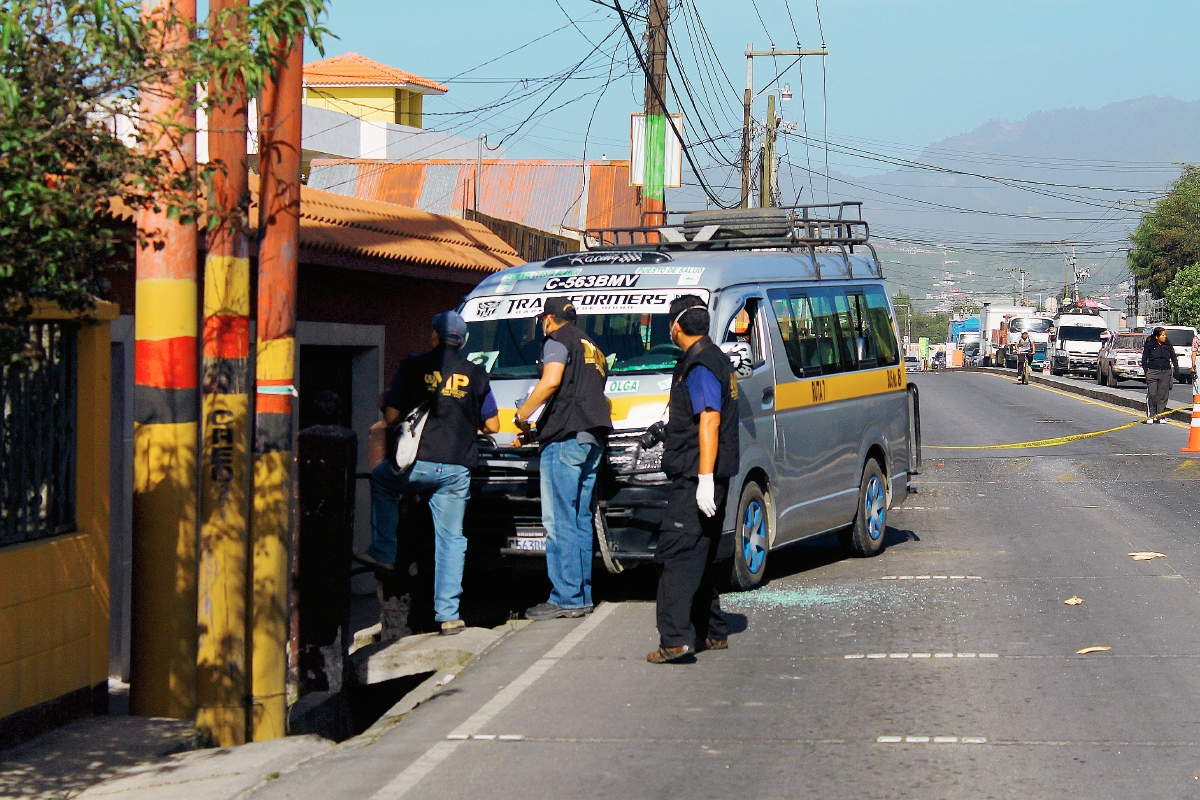 Fiscales del Ministerio Público trabajan en la escena donde fue atacado el piloto del microbús, en el kilómetro 207 en jurisdicción de La Esperanza, Quetzaltenango. (Foto Prensa Libre: Carlos Ventura)