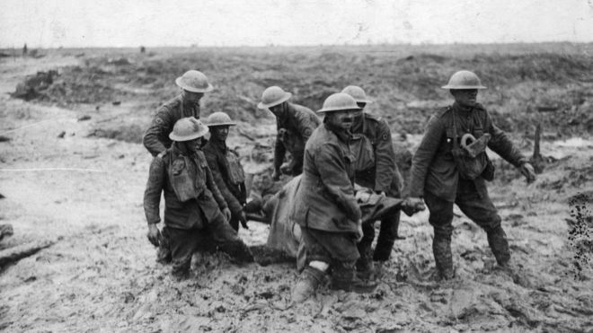 Soldados sacan del lodo a un compañero muerto en combate.