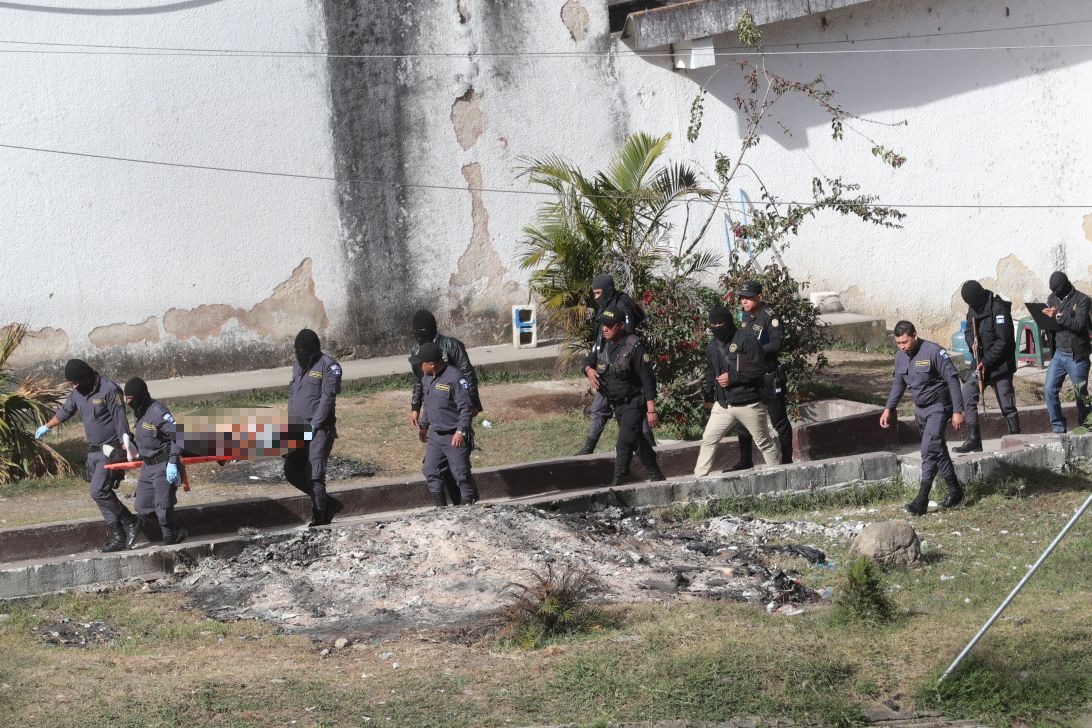 Guardias penitenciarios extraen uno de los cuerpos de los pandilleros asesinados. (Foto Prensa Libre: Estuardo Paredes).
