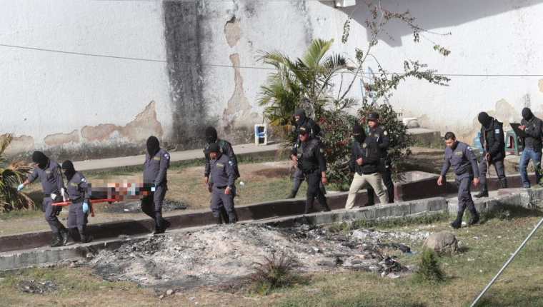 Guardias penitenciarios extraen uno de los cuerpos de los pandilleros asesinados. (Foto Prensa Libre: Estuardo Paredes).