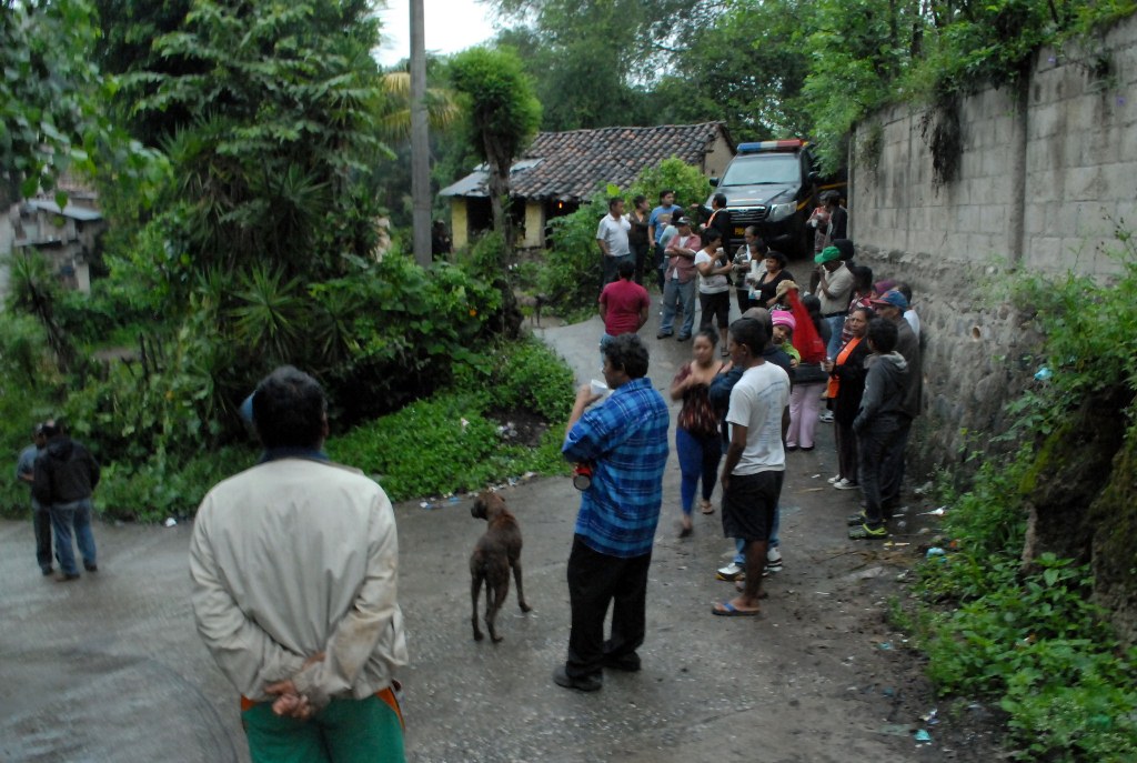 Curiosos permanecen cerca de la vivienda donde fue localizado el cuerpo de Chajón, en Sanarate, El Progreso. (Foto Prensa Libre: Hugo Oliva).