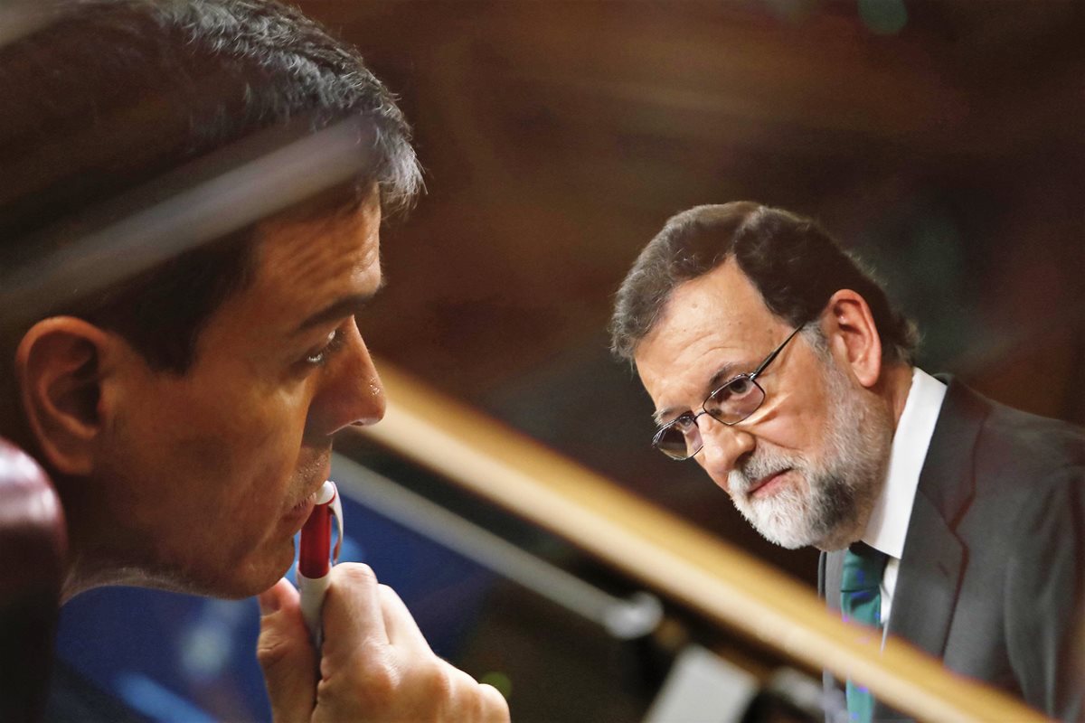 El nuevo presidente del gobierno de España, Pedro Sánchez, escuchando el discurso de su antecesor, Mariano Rajoy. (Foto Prensa Libre: EFE)