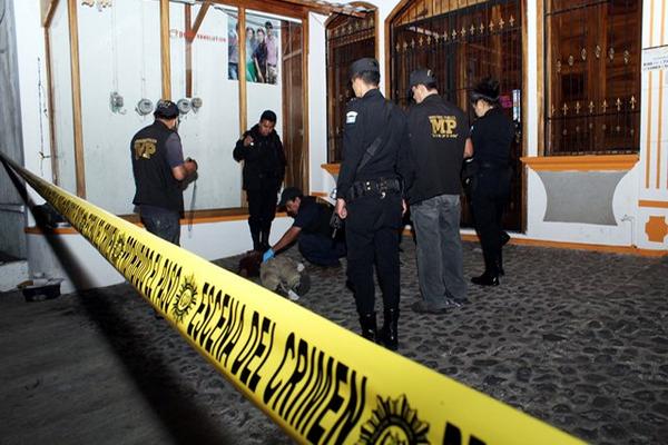 Agentes de la Policía Nacional Civil y del Ministerio Público recaban datos de crimen en sector comercial de la zona 1 de Retalhuleu. (Foto Prensa Libre: Rolando Miranda)<br _mce_bogus="1"/>