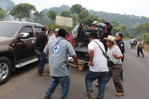 Socorristas y vecinos suben a un autopatrulla el cadáver de Marco Antonio Can, quien fue encontrado muerto en San Lucas Tolimán. (Foto Prensa Libre: Édgar Sáenz)