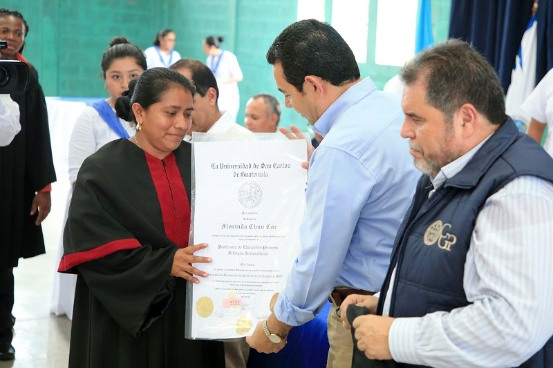 El presidente Jimmy Morales entrega el título a una maestra graduada del programa de formación docente, en Morales, Izabal. (Foto Prensa Libre: Dony Stewart)