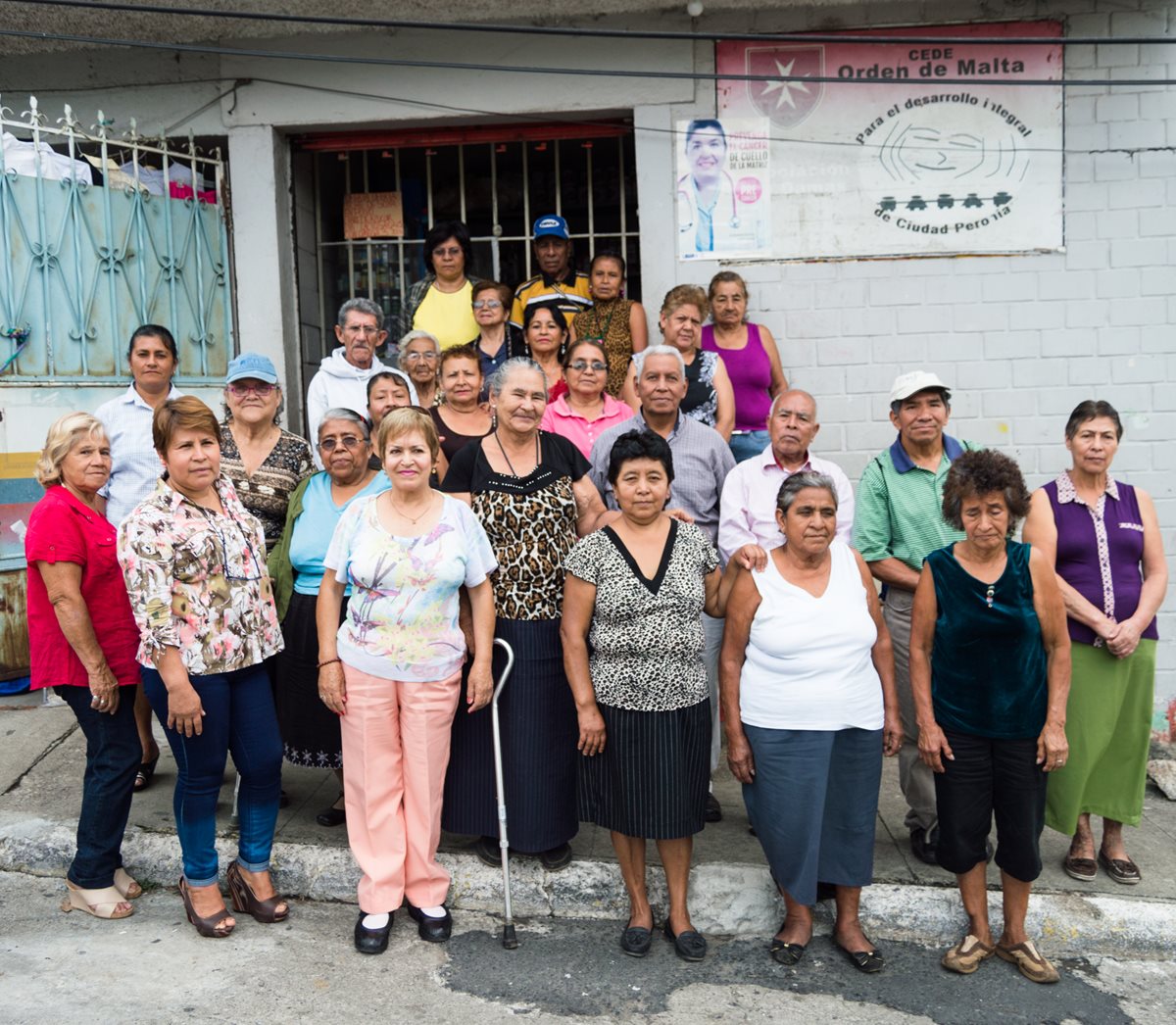 Mayra Escobar (con pantalón de lona y blusa estampada) y algunas integrantes de la asociación posan con varios abuelitos a los que ayudan. Foto Prensa Libre: Roberto Villalobos Viato.