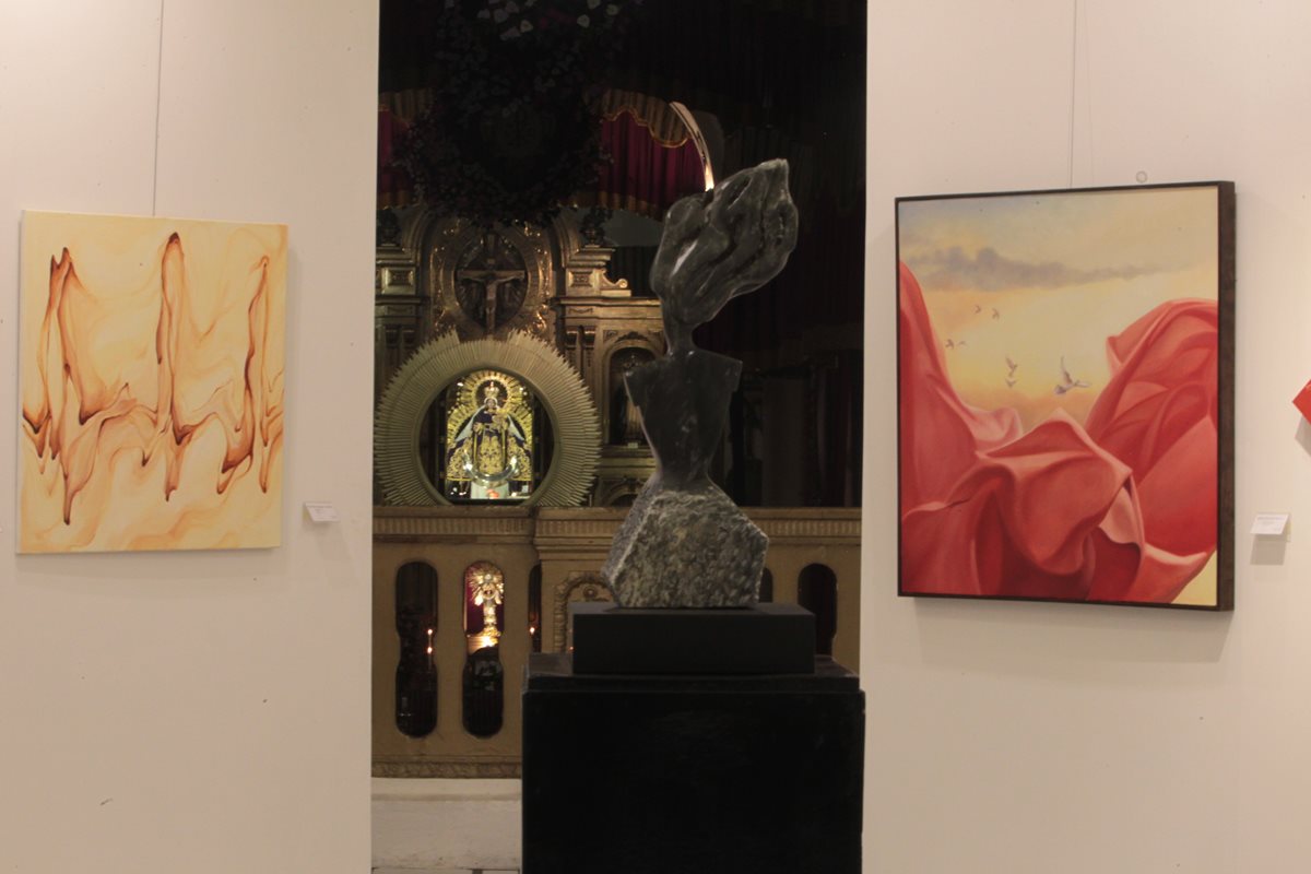 El altar mayor del templo Santo Domingo brilla al fondo, entre las obras en exhibición. (Foto Prensa Libre: Edwin Castro)