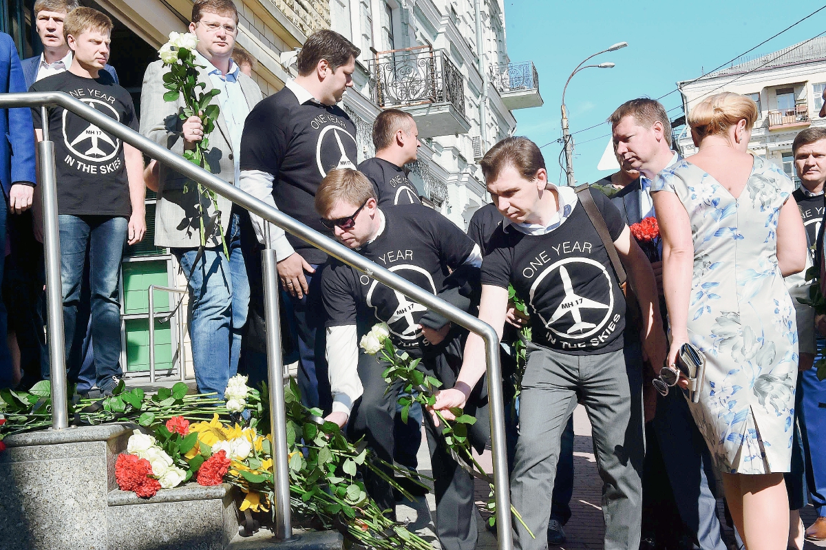 Varias personas depositar flores en frente de la embajada holandesa en Kiev en la memoria de las personas que murieron en el vuelo MH17. (Foto Prensa Libre:AFP
