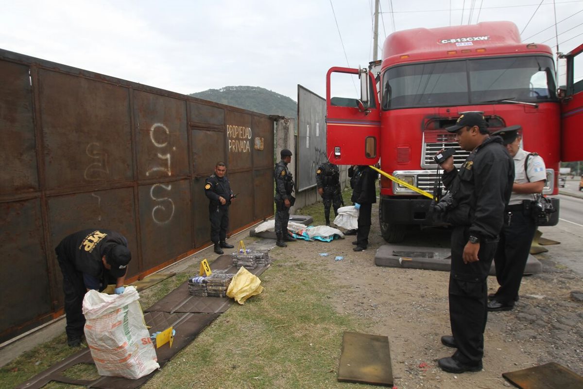 Agentes antinarcóticos y peritos del MP embalan los paquetes con cocaína, incautados en el kilómetro 18 de la ruta al Atlántico. (Foto Prensa Libre: Érick Ávila)