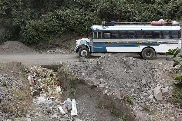Un autobús circula por un   tramo en el que solo hay un carril, debido a los derrumbes, en la ruta entre  San Pedro Yepocapa  y Parramos.