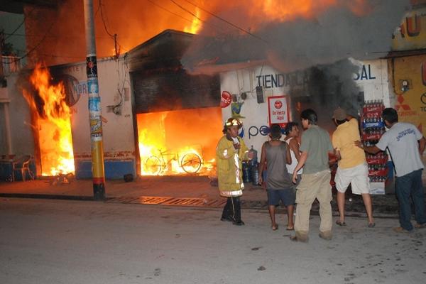 Bomberos y vecinos intentan reducir las llamas provocadas por las granadas. (Foto Prensa Libre: Rigoberto Escobar)<br _mce_bogus="1"/>