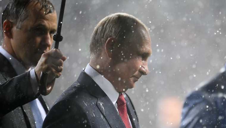 El presidente de Rusia fue el único que tuvo paraguas de la organización o de su servicio de seguridad. Minutos después reaccionaron para cubrir a los otros mandatarios. (Foto Prensa Libre: AFP)