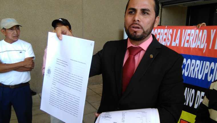 El abogado Elmer Salguero muestra, afuera de la sede central del MP, copias de denuncias y actas electorales. (Foto, Prensa Libre: Rosa María Bolaños).