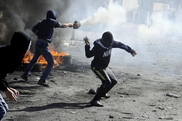 Palestinos lanzan rocas y petardos contra la policía israelí en un nuevo enfrentamiento. (Foto Prensa Libre: AP)<br _mce_bogus="1"/>