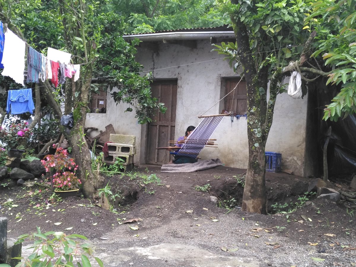 Una mujer teje en su vivienda en Panabaj. (Foto Prensa Libre: Ángel Julajuj)