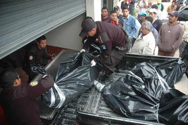 <span style="font-family: Calibri; font-size: small;" _mce_style="font-family: Calibri; font-size: small;">Policías bajan de un autopatrulla los cadáveres de dos hombres y una mujer, que fueron localizados en Flores, Petén. (Foto Prensa Libre: Rigoberto Escobar)</span>