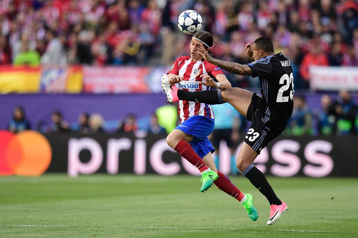 Filipe Luis pelea la pelota con su compatriota Danilo del Real Madrid.