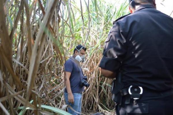 Un agente policial observa el cadáver que tenía balazos en la cabeza y el torax. (Foto Prensa Libre: Enrique Paredes)<br _mce_bogus="1"/>