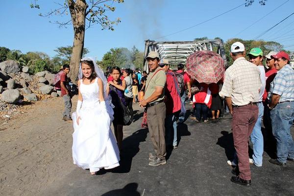 La novia Kenia Alvarado pasa a pie  en el km 179 de la ruta al suroccidente, debido a la manifestación. (Foto Prensa Libre: Rolando Miranda)