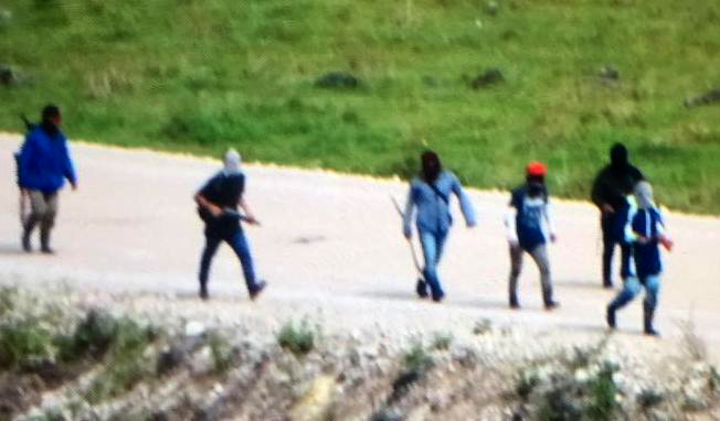 Un grupo de manifestantes camina en la carretera principal de Ixquisis, algunos portan armas de fuego. (Foto Prensa Libre).