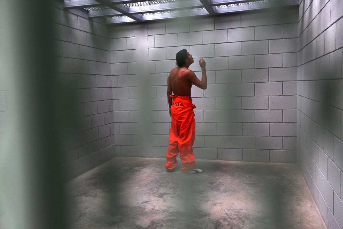 Un reo observa hacia arriba de su celda, de 2 por 2 metros, en la prisión "El Pozo", ubicada en Santa Bárbara, Honduras. (Foto Prensa Libre: AFP).