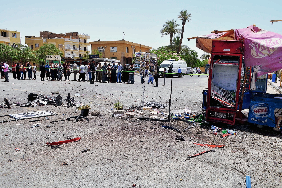 Varios curiosos observan el lugar del atentado suicida, cerca en Luxor, Egipto. (Foto Prensa Libre:AFP)
