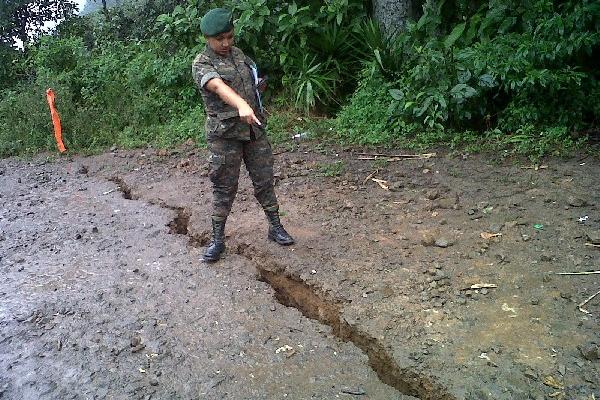 Militar muestra una de las grietas en  el caserío Ixcaíl,  San Miguel Ixtahuacán.