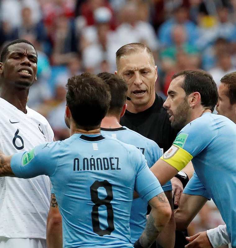 Jugadores de Uruguay discuten con el árbitro argentino Néstro Pitana. (Foto Prensa Libre: EFE)