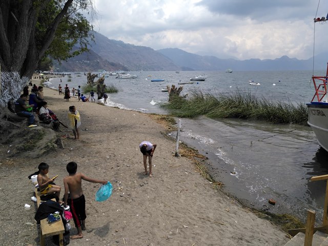 Vecinos y comerciantes recolectan desechos en la playa pública de Panajachel, Sololá. (Foto Prensa Libre: Ángel Julajuj)