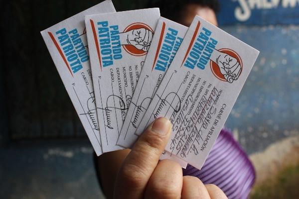 Pobladora muestra varios carné de afiliación del partido oficial. (Foto Prensa Libre: Oswaldo Cardona)