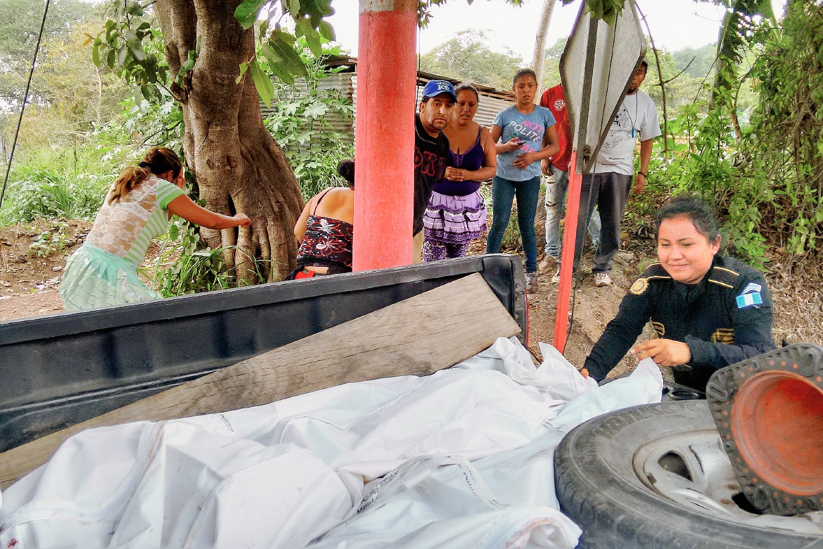 Agentes de  la PNC trasladan los cuerpos de los trabajadores de la finca Morelia hacia la morgue del Instituto Nacional de Ciencias Forenses. (Foto Prensa Libre: Oswaldo Cardona)