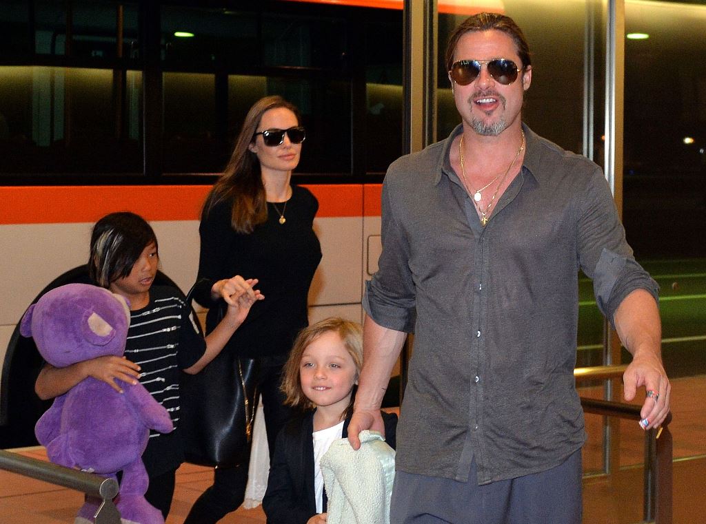 Angelina Jolie y Brad Pitt acompañados por sus hijos durante una visita a Tokio en 2013. (Foto Prensa Libre: AFP)