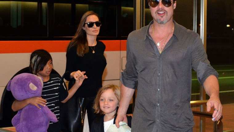 Angelina Jolie y Brad Pitt acompañados por sus hijos durante una visita a Tokio en 2013. (Foto Prensa Libre: AFP)