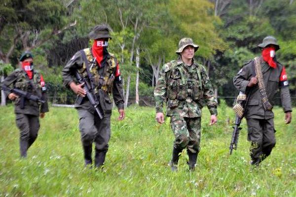 Un militar es escoltado por miembros de la guerrilla colombiana ELN, durante un proceso de liberación. (Foto Prensa Libre: AFP)