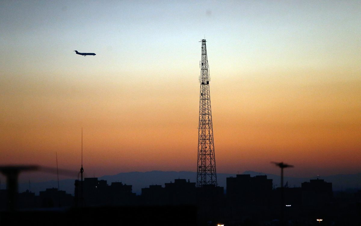 Un avión de pasajeros iraní pasa junto a una colorida puesta de sol que ilumina el cielo en la capital iraní Teherán, Irán. (Foto Prensa Libre:EFE).