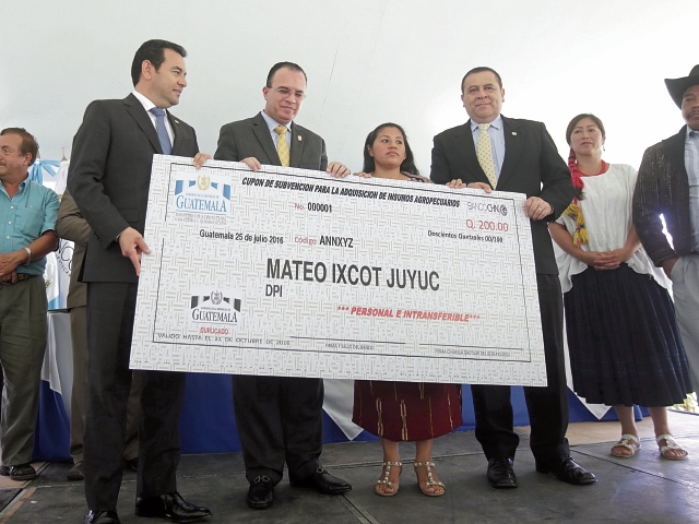 El Presidente Jimmy Morales, junto a autoridades del Maga, entregó de manera simbólica el cupón de Q200 que recibirán campesinos de varias comunidades del país. Fotografia: Paulo Raquec