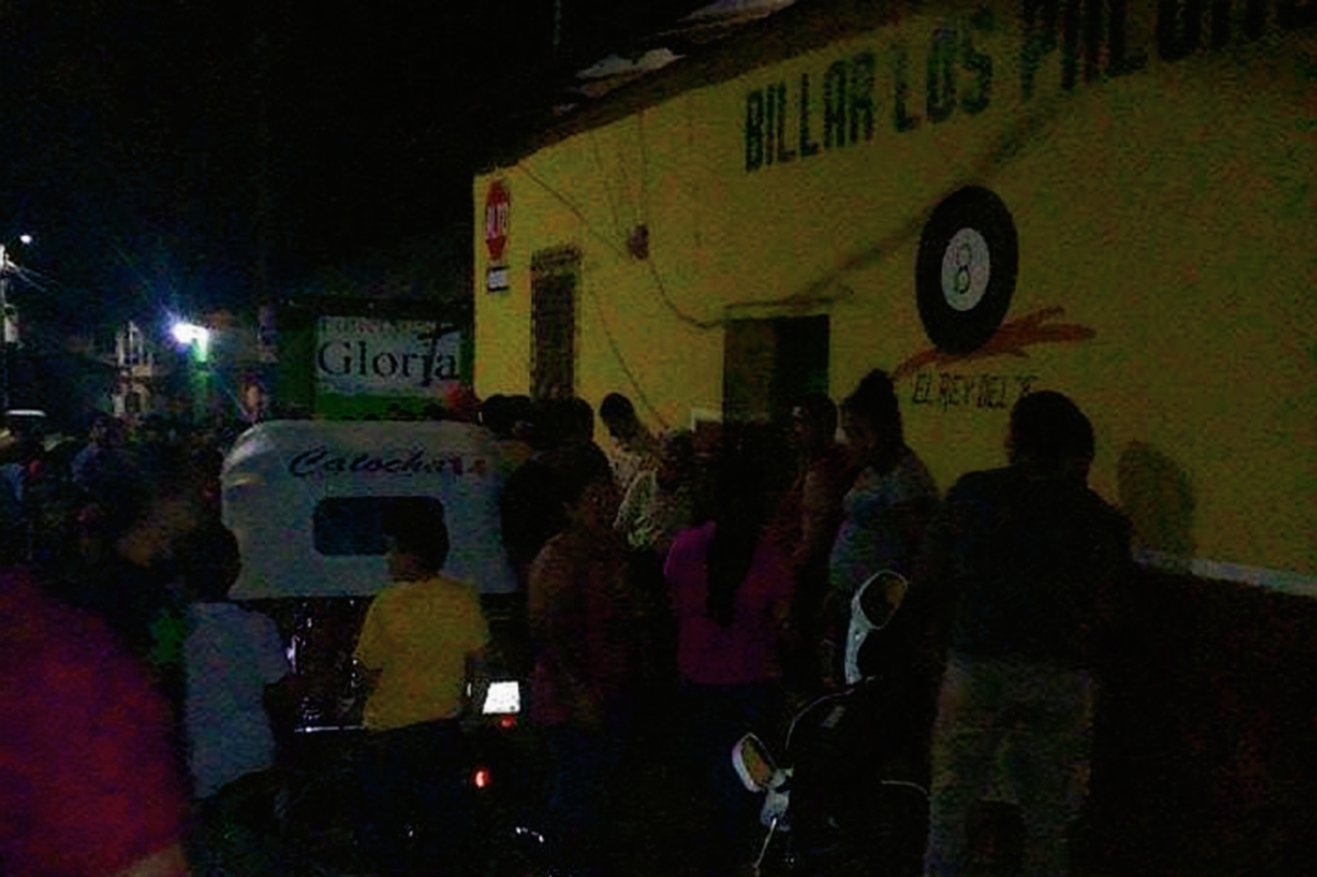 Vecinos del centro de Santa Catarina Mita, Jutiapa, se aglomeran enfrente de un billar, donde murió un hombre a balazos. (Foto Prensa Libre: Óscar González)