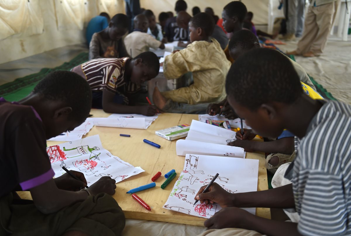 Un grupo de refugiados nigerianos jóvenes reciben un programa de terapia administrada por Unicef. (Foto Prensa Libre:AFP)