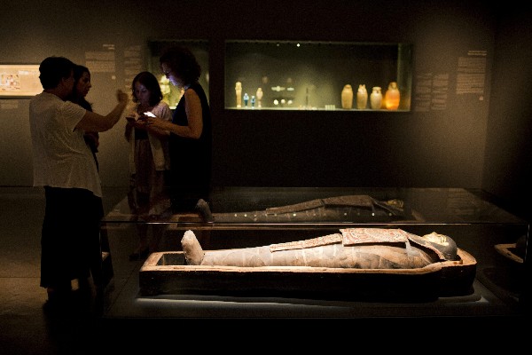 Visitantes permanecen junto a una momia egipcia de dos mil 200 años. (Foto Prensa Libre: EFE)