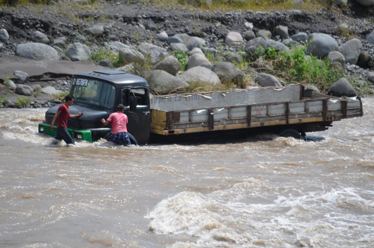 Trabajadores de un camión de piedra fueron sorprendidos por una correntada del río Samalá, en Santa Cruz Muluá. (Foto Prensa Libre: Jorge Tizol)