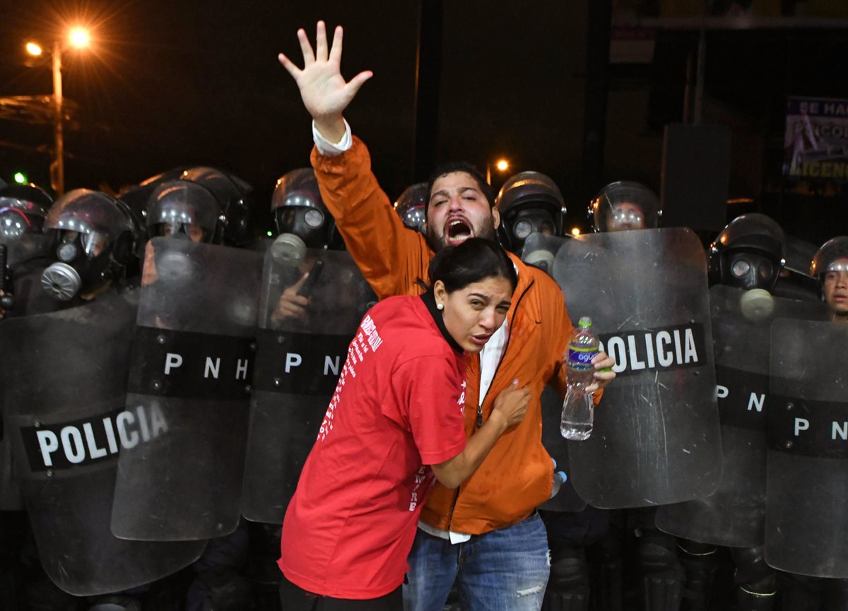 Seguidores de Nasralla resultaron heridos tras enfrentarse con fuerzas de seguridad cuando intentaron llegar a bodega electoral. (Foto Prensa Libre: EFE)