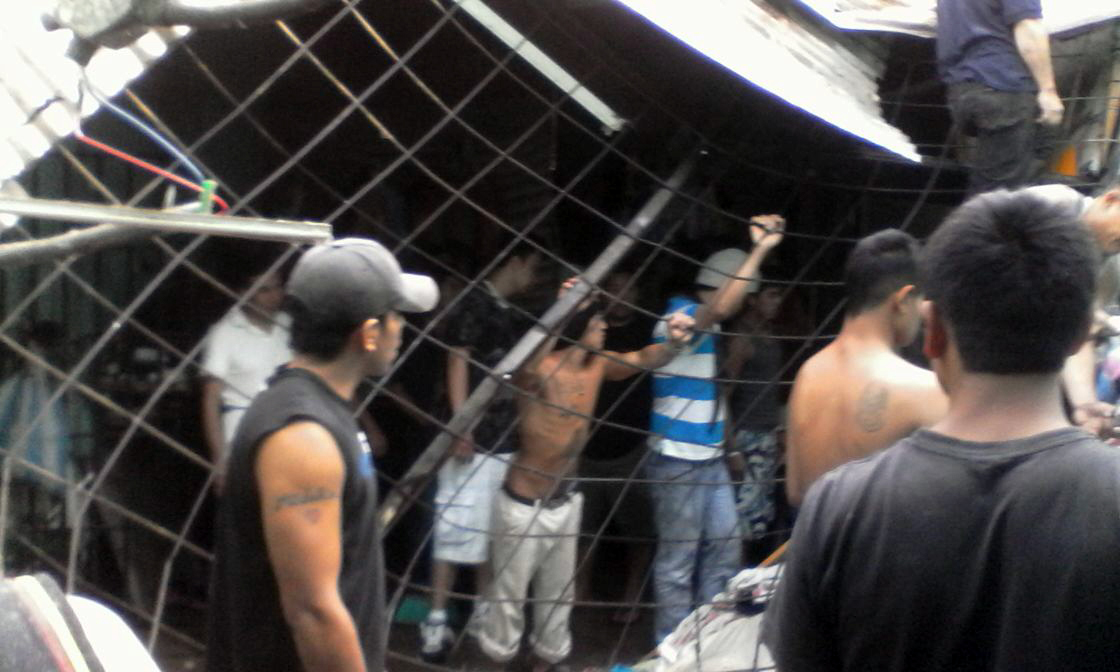 Un grupo de reos de la cárcel para hombres de Jalapa observa los daños en el techo de esa prisión. (Foto Prensa Libre: PNC)