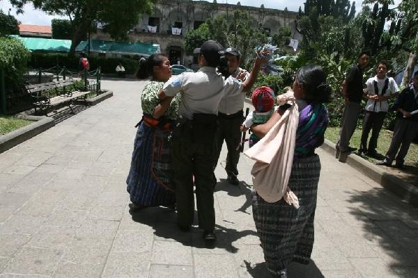 La imagen, captada en  julio del 2010, muestra el momento en que  policías  de Turismo arrebatan collares típicos a vendedora.