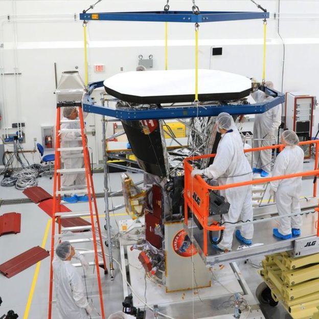 Los ingenieros del Laboratorio de Física Aplicada de la Universidad John Hopkins colocan el escudo protector sobre la sonda. El escudo está pintado de blanco para reflejar la luz del Sol. (NASA/John Hopkins APL)